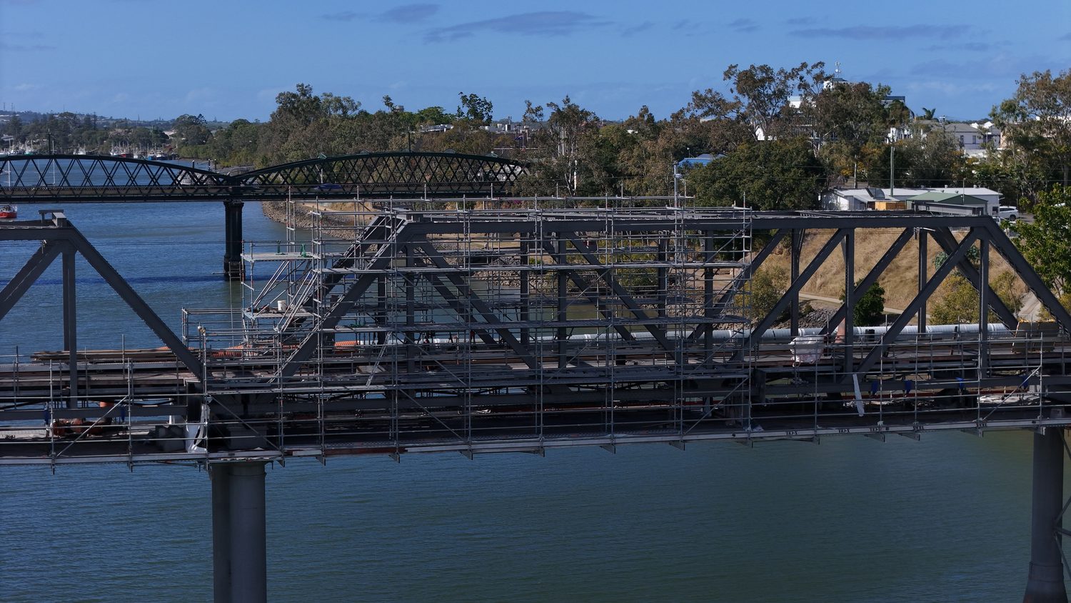 Aerial drone inspection view of a steel rail bridge over the Burnett River, Queensland